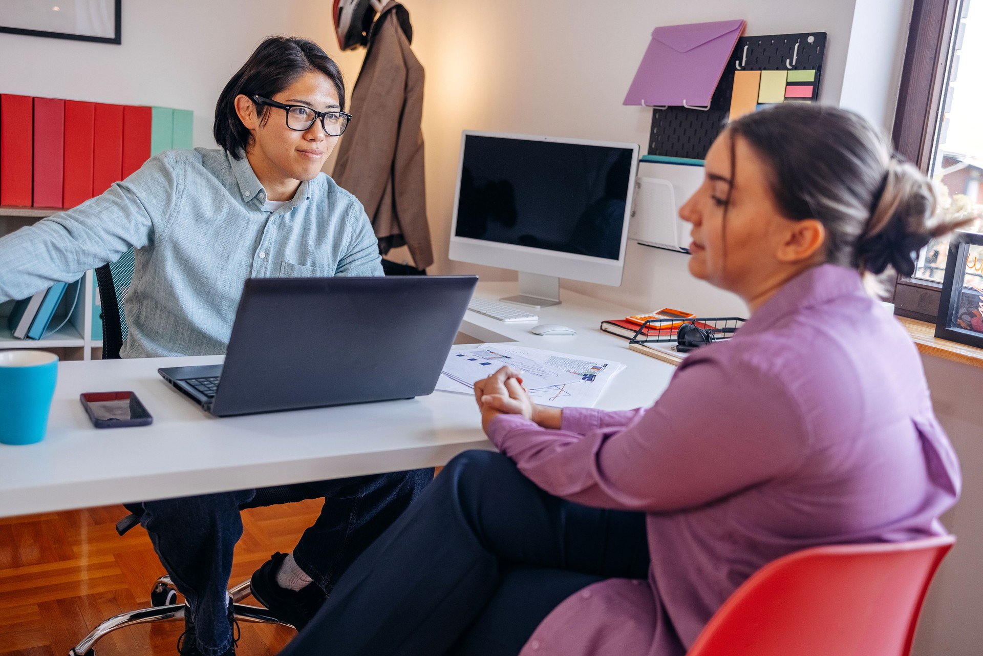 Financial advisor working in office using laptop and talking with client